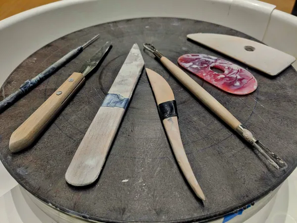 A closeup of hand-carving tools on a workbench.